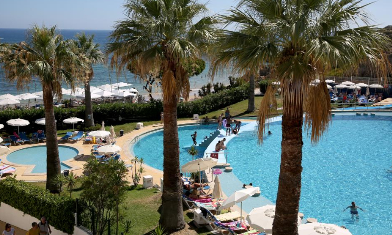Beachgoers sunbathe and swim at Oura beach in Albufeira, Algarve region, Portugal on Aug. 6, 2022. Tourism is rebounding quickly in Portugal.  Photo: Xinhua