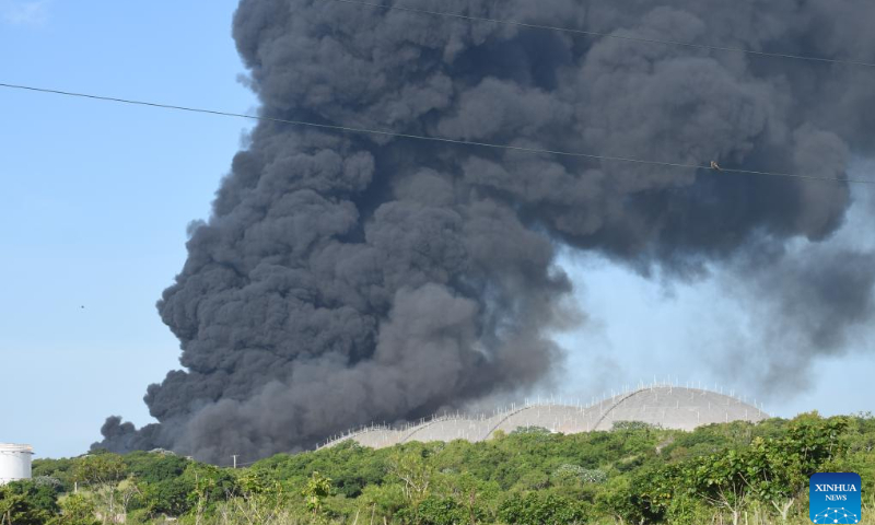 Thick smoke is seen from the burning fuel storage tank near the port of Matanzas, Cuba, Aug. 7, 2022. At least one person was killed and 122 injured in a large-scale fire following a series of explosions at a fuel storage facility in Cuba, the Ministry of Public Health said Sunday, adding that 16 others were still missing in the accident.  Photo: Xinhua