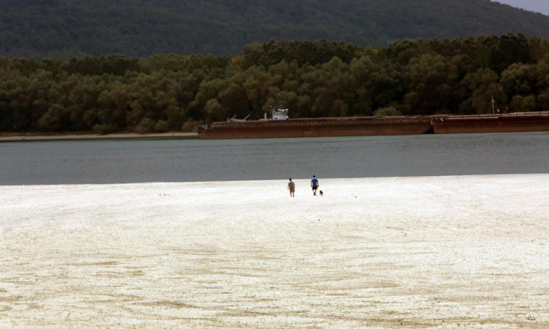 People walk on the dry bed of Danube River in Teleorman County, Romania, Aug. 7, 2022. Romania is facing severe drought this summer. Photo: Xinhua