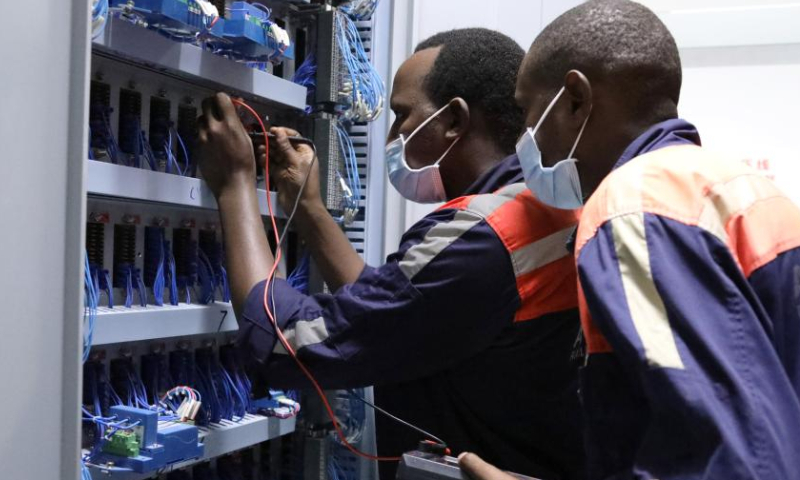 Signal workers Daniel Kibe (L) and Patrick Mburu check signal equipments at Mombas Terminus Station in Mombasa, Kenya, July 27, 2022. Launched on May 31, 2017, the 480 km Mombasa-Nairobi Standard Gauge Railway (SGR), financed mainly by China and constructed by China Road and Bridge Corporation (CRBC), has fostered job creation for local people. Photo: Xinhua