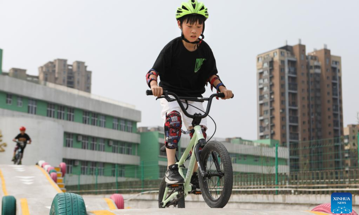 A child practises bicycle riding as part of a summer caring program at a primary school in Shenyang, northeast China's Liaoning Province, Aug 4, 2022. Photo:Xinhua