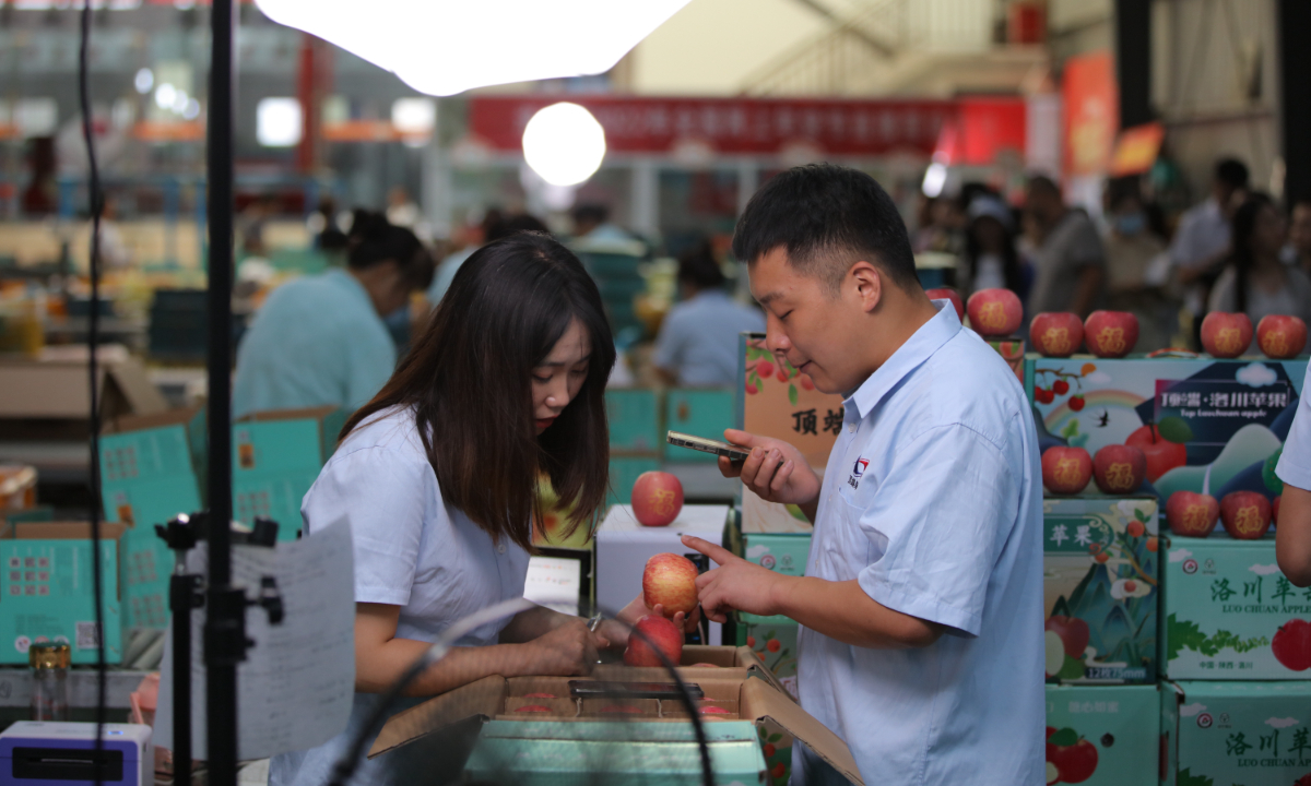 Staff members sell Luochuan apples via live stream in Luochuan in Yan'an, northwest China's Shaanxi Province, on Aug. 4, 2022.  Photo: Xiao Yi/ China Economic Weekly