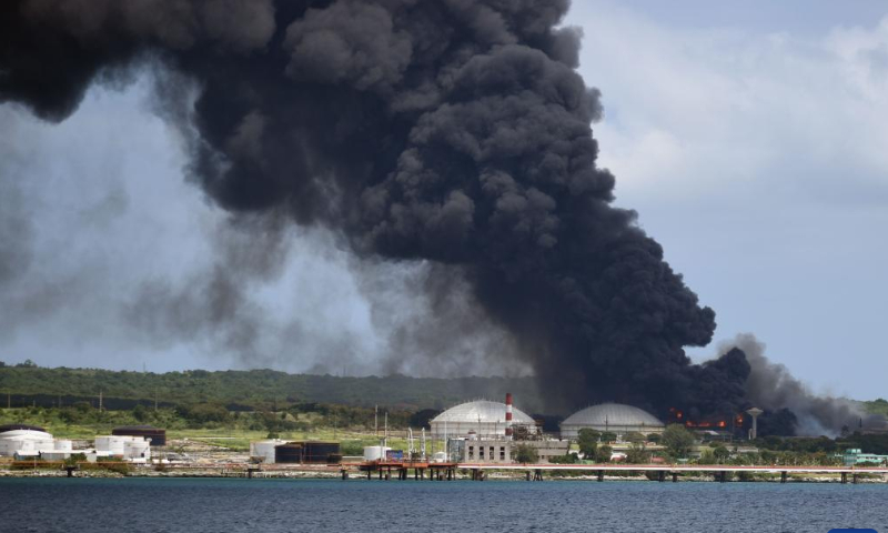 Thick smoke is seen from the burning fuel storage tank near the port of Matanzas, Cuba, Aug. 7, 2022. At least one person was killed and 122 injured in a large-scale fire following a series of explosions at a fuel storage facility in Cuba, the Ministry of Public Health said Sunday, adding that 16 others were still missing in the accident.  Photo: Xinhua