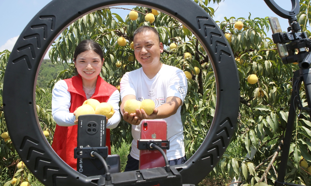 Farmers and volunteers in Yichun, East China's Jiangxi Province, recommend yellow peaches via a livestream feed and short videos on July 30, 2022. Photo: VCG