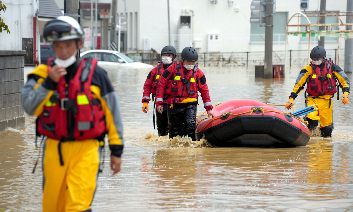 Rescue workers search for those who are unable to evacuate at a residential area after torrential rain hit the region on August 4, 2022 in Murakami, Japan. Photo: VCG