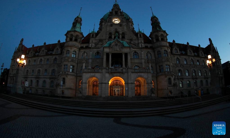 Photo taken on Aug. 1, 2022 shows a night view of the city hall in Hanover, Germany. Some landmark structures across the country have reduced their night illumination to save on electric power. (Photo by Joachim Sielski/Xinhua)