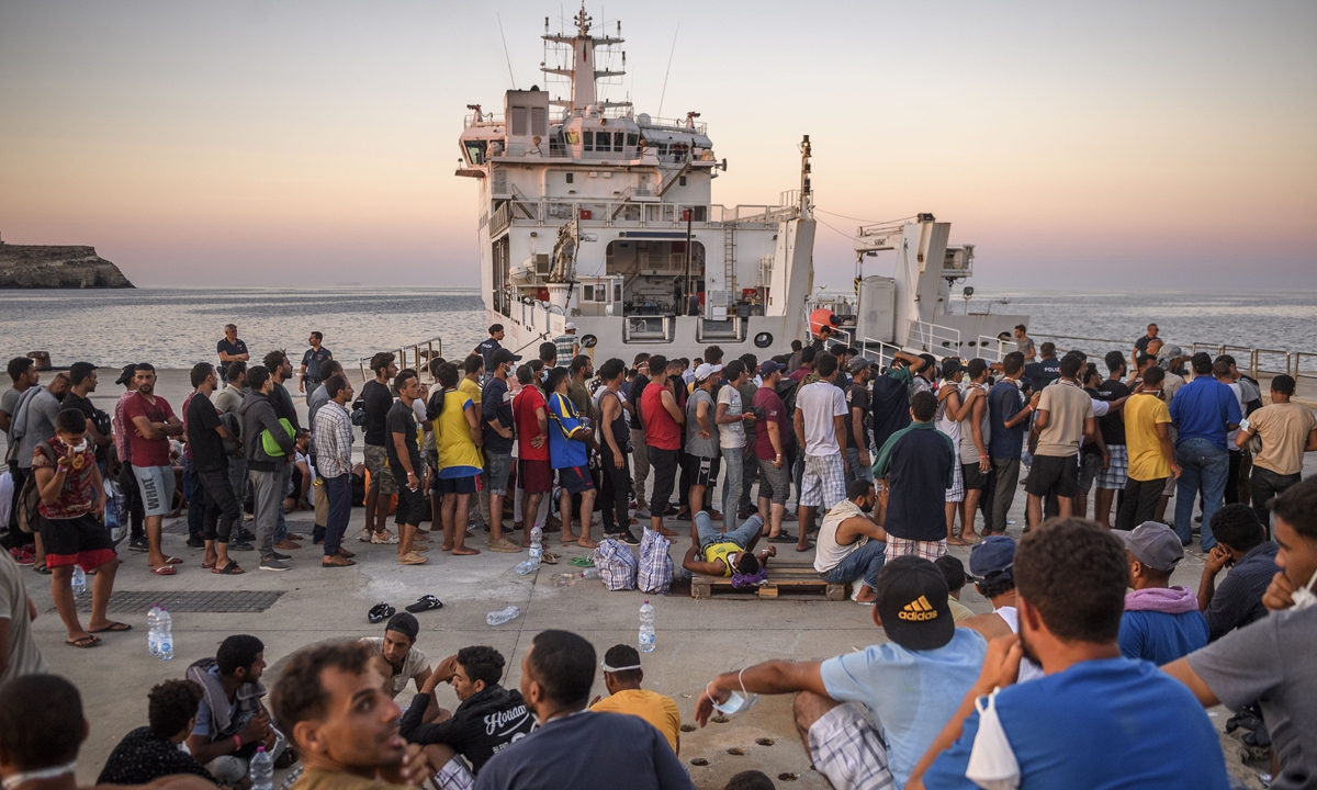 Migrants wait to board the Coast Guard ship Diciotti before being transferred to Porto Empedocle from the so-called Hotspot operational facility, containing over 1,700 people, on August 3, 2022, in Lampedusa, Italy. The Italian island of Lampedusa reached 500 percent over capacity in migrant reception centers with the recent uptick in sea rescues. Photo: VCG