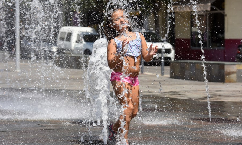 A girl plays at a fountain to cool off in Coria, Spain on July 30, 2022.(Photo: Xinhua)