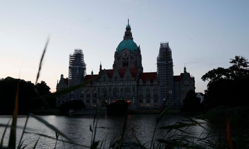 Photo taken on Aug. 1, 2022 shows a night view of the city hall in Hanover, Germany. Some landmark structures across the country have reduced their night illumination to save on electric power. (Photo by Joachim Sielski/Xinhua)