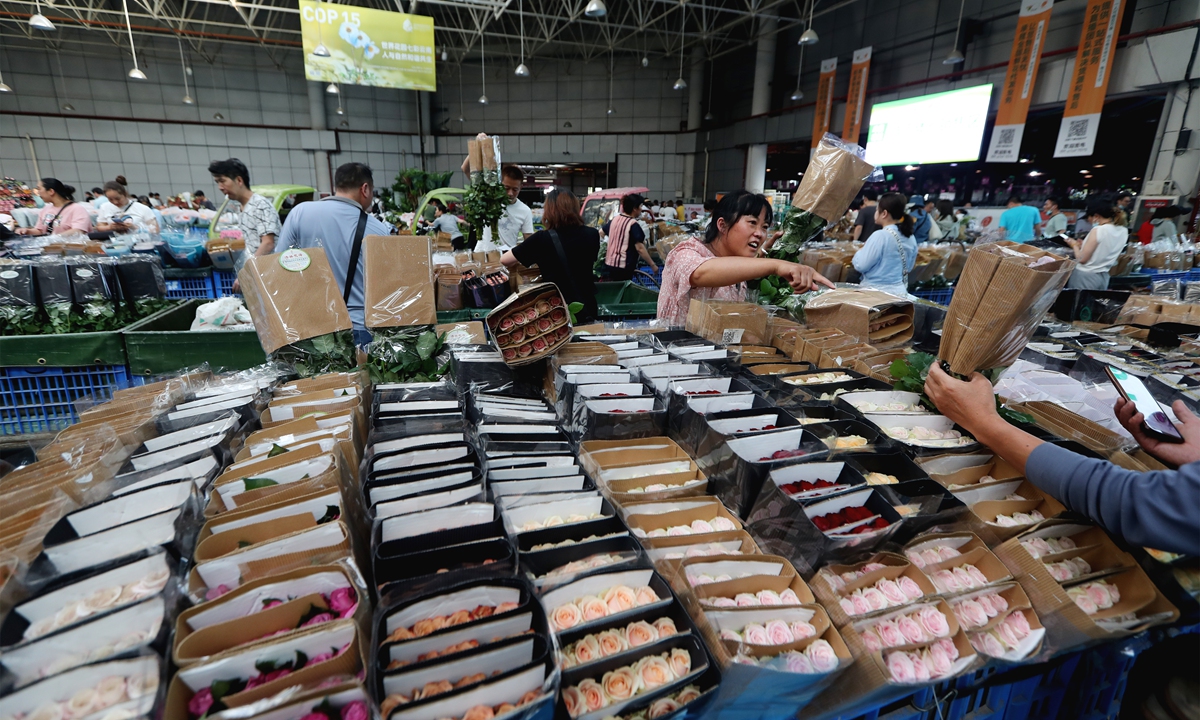 People buy flowers, mainly roses, at the Dounan Flower Market in Kunming, Southwest China's Yunnan Province, on August 2, 2022. The Qixi Festival, or Chinese Valentine's Day, falls on August 4, and it's boosting the flower industry. The daily trading volume of flowers in the Dounan market has reached 30 million. Photo: VCG 