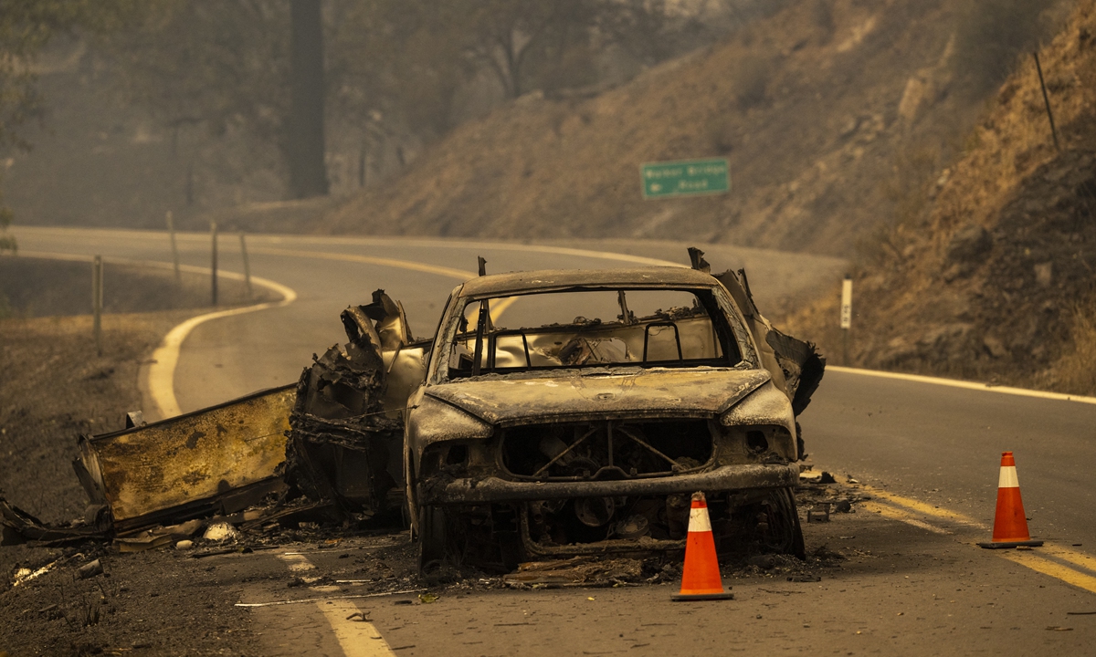 The charred remnants of a car towing a trailer that burned when fire jumped the Klamath River remain on the highway at the McKinney Fire in the Klamath National Forest northwest of Yreka, California, on July 31, 2022. Photo: AFP