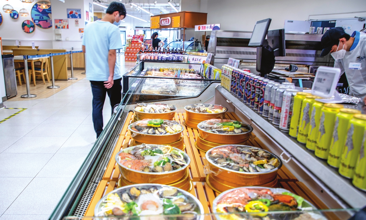 A consumer checks prefabricated food in a supermarket. Photo: VCG