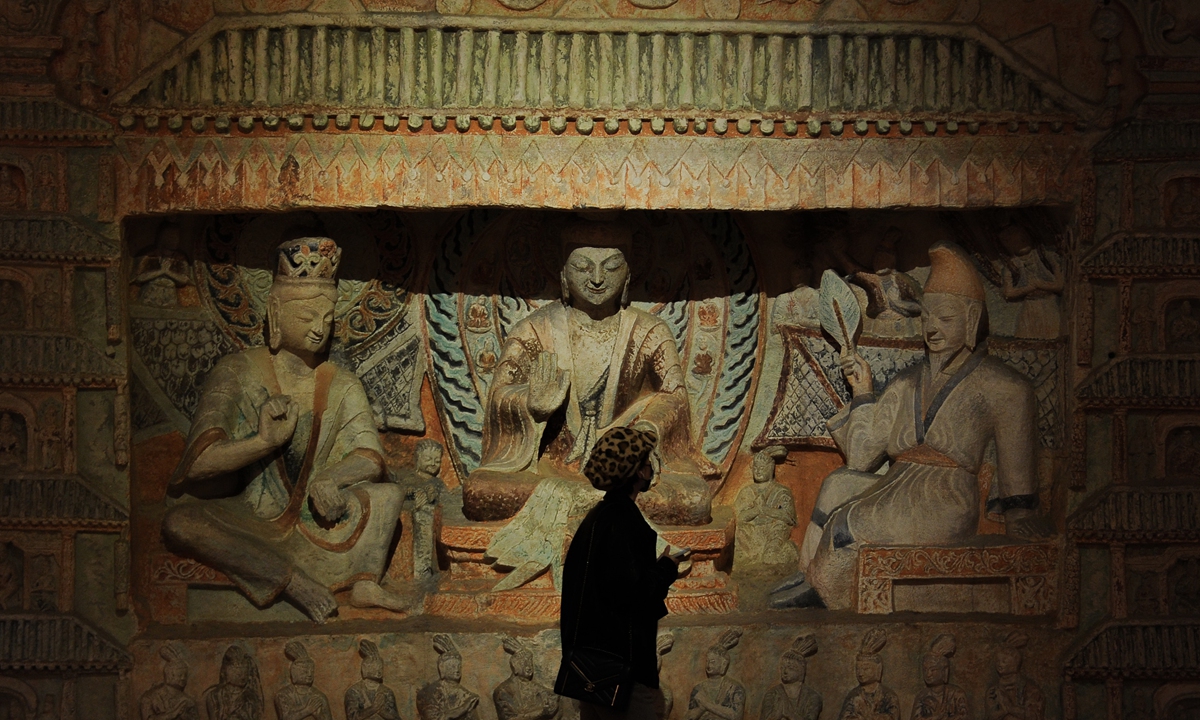 Buddhist statues at the Yungang Grottoes Photo: VCG  A viewer looks at a 3D replica of the Yungang Grottoes' No.6 cave. Photo: IC