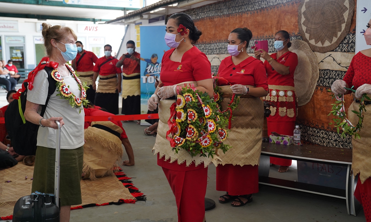 An international visitor is welcomed with a kahoa (garland) by Tonga Ministry of Tourism staff upon arriving at Fua'amotu International Airport in Tonga on August 1, 2022. Photo: AFP
