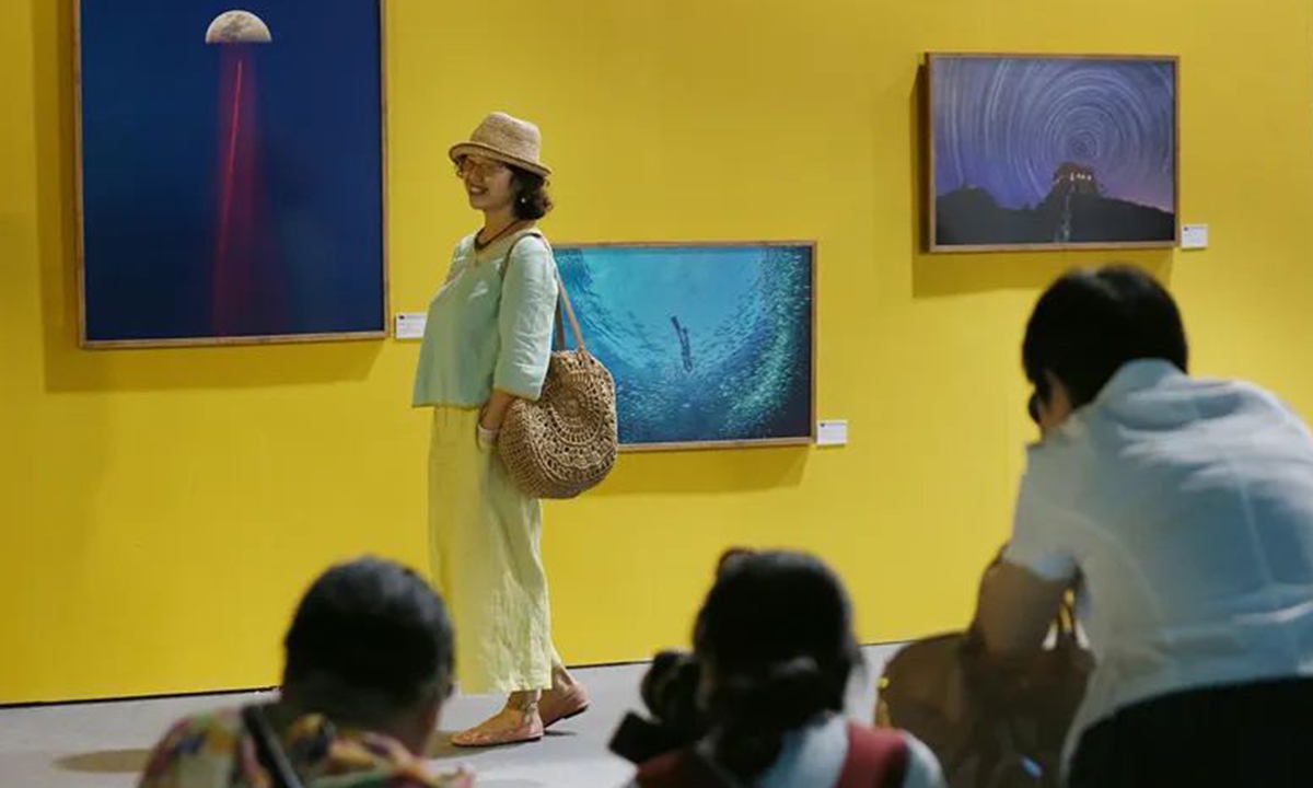 Visitors pose in front of artworks at the 18th China International Photographic Art Exhibition (CIPAE), which is kicked off in Wuxi, East China's Jiangsu Province, on August 3, 2022. Photo: Courtesy of Zhang Shuangshuang