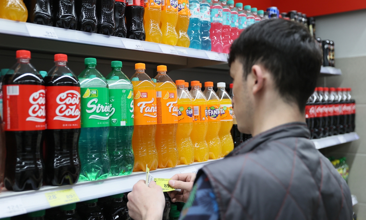 A Russian supermarket staff checks items placed on shelves. Photo: VCG