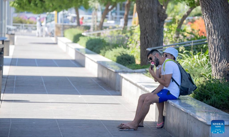 A man eats ice cream in the shade in Limassol, Cyprus, on Aug. 4, 2022. The Cypriot Department of Meteorology on Thursday issued a new yellow warning for high temperature.(Photo: Xinhua)