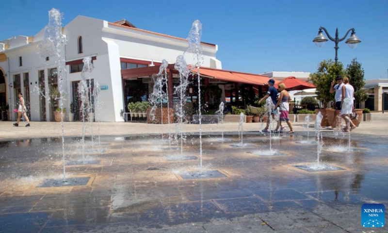 People walk past a splash pad in Limassol, Cyprus, on Aug. 4, 2022. The Cypriot Department of Meteorology on Thursday issued a new yellow warning for high temperature.(Photo: Xinhua)