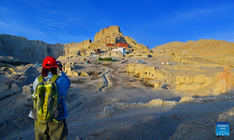 A tourist takes photos of the ruins of the Guge Kingdom in Zanda County of Ngari Prefecture, southwest China's Tibet Autonomous Region, Aug. 3, 2022.(Photo: Xinhua)