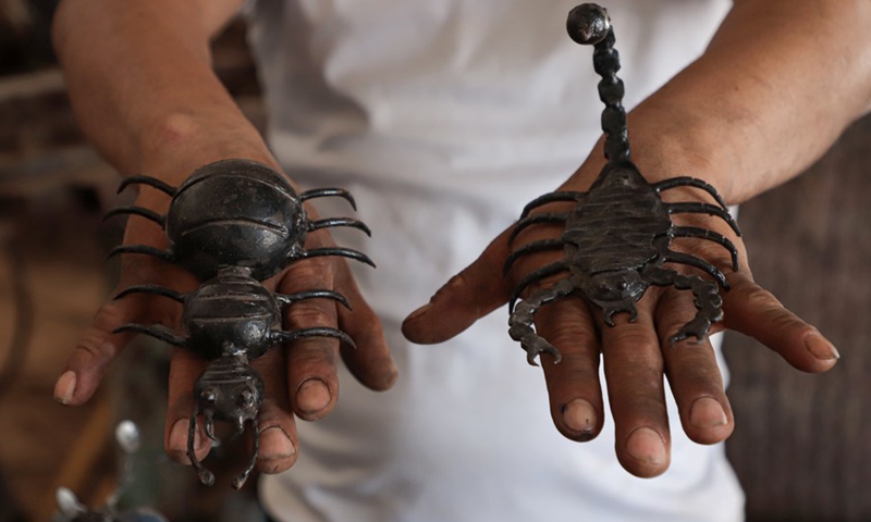 Palestinian hearing impaired Fakher Hamad displays art sculptures at his small workshop in Gaza City, on Aug. 2, 2022. (Photo: Xinhua)