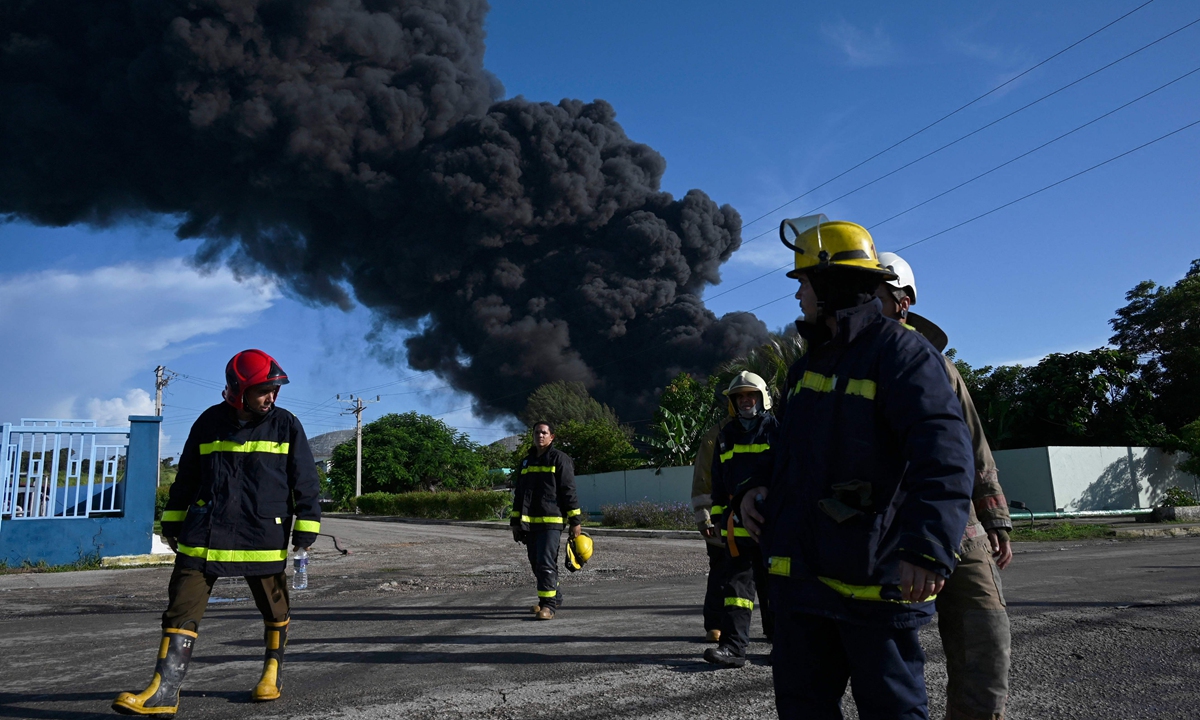 Firefighters are seen near an oil tank on fire in Matanzas, Cuba, on August 6, 2022. The fire caused by lightning on Friday in a fuel depot in Matanzas, western Cuba, spread to a second tank on Saturday. Authorities said at least 121 people were injured in the second blast, of which 36 remained hospitalized, five in critical condition. One person was listed as dead and 17 firefighters were unaccounted for. Photo: VCG