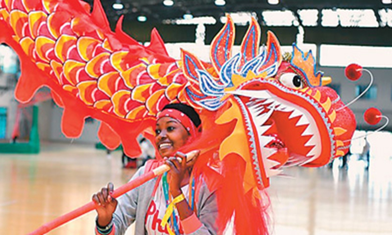 Comorian girl La Yisha experiences dragon dance at Sias University in Zhengzhou, Henan Province. Photo: Yuan Chen/Xinhua News Agency