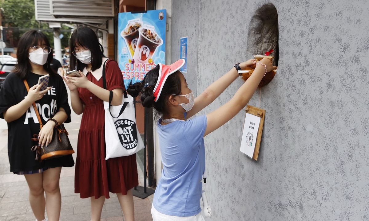 People order coffee outside Shanghai's Bear Paw Cafe. Photos: IC An employee of Shanghai's Bear Paw Cafe hands out a cup of coffee. 