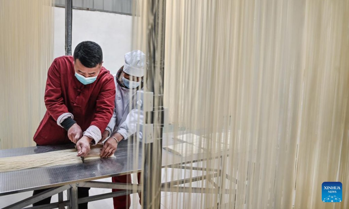 Li Nianping (L), son of Li Changman, cuts noodles at a noodle cooperative of Li Changman in Meidi Village of Bao'an Township in Luonan County of Shangluo City, northwest China's Shaanxi Province, March 18, 2022. Photo:Xinhua