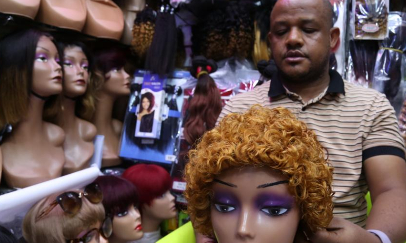 A hairstylist arranges a wig for display at a shop in Dar es Salaam, Tanzania, on Aug. 13, 2022. Photo: Xinhua