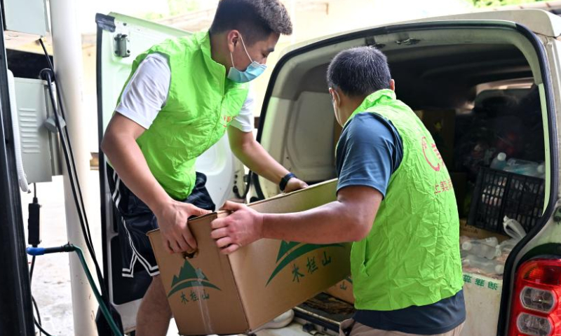 Staff members load daily life supplies to a vehicle at a dispatch site of an on-line shopping service in Sanya, south China's Hainan Province, Aug. 13, 2022.  Photo: Xinhua
