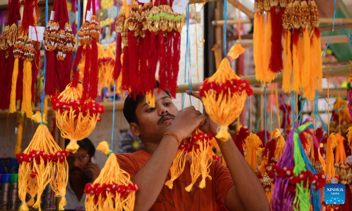 A customer buys Rakhi sacred threads for the Raksha Bandhan festival at a shop in Agartala, India, Aug 11, 2022. Photo:Xinhua