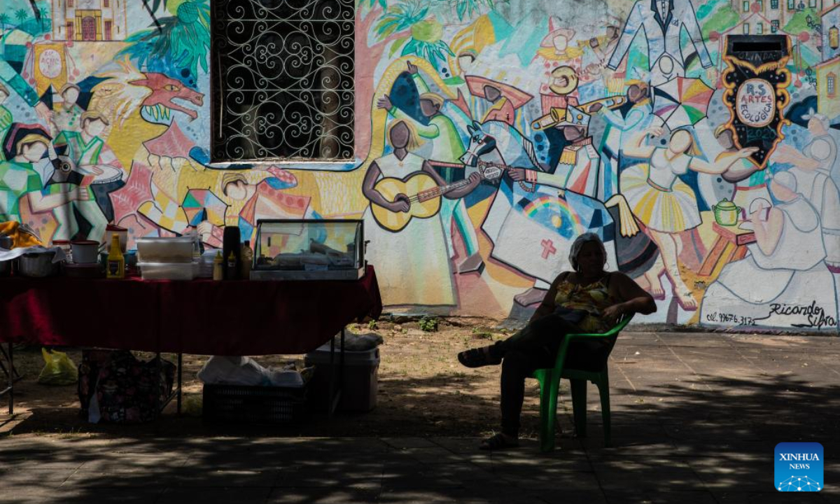 A woman sits in front of mural paintings in Olinda, Brazil, Aug 11, 2022. The Historic Centre of the Town of Olinda was inscribed on the UNESCO World Heritage List in 1982. Photo:Xinhua