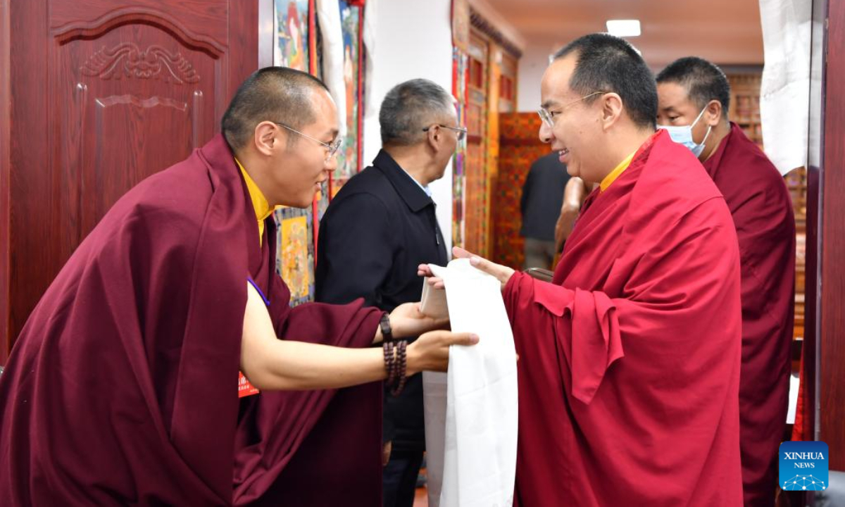 A Buddhist monk presents a hada, a silk scarf used to express respect and greeting, to Panchen Erdeni Chos-kyi rGyal-po on June 2, 2022. Panchen Erdeni Chos-kyi rGyal-po had performed his daily duties as president of the Tibet branch of the Buddhist Association of China in Lhasa since mid-May. Photo:Xinhua