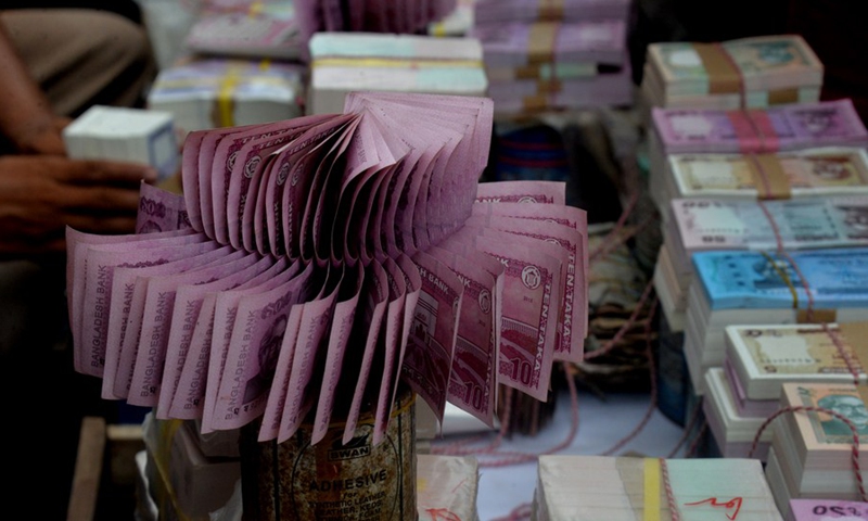 The photo taken on June 23, 2017 shows bundles of currency notes of taka (Bangladeshi currency) at a footpath stall in Dhaka, capital of Bangladesh, on June 23, 2017.(Photo: Xinhua)