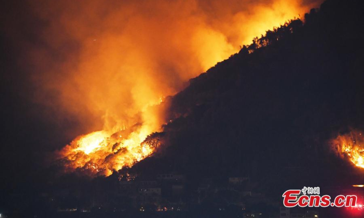 A massive fire burns on a mountain in Fuling district of Chongqing, Aug 19, 2022. Firefighters battle to contain the blaze. Photo:China News Service