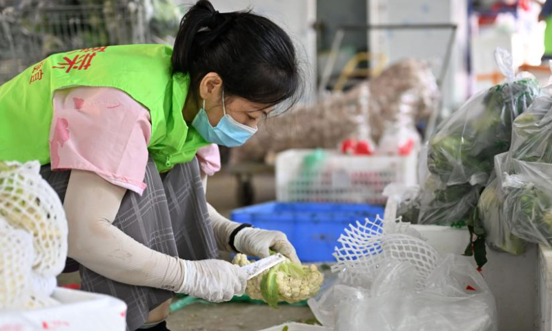 A staff member processes vegetables at a dispatch site of an on-line shopping service in Sanya, south China's Hainan Province, Aug. 13, 2022.  Photo: Xinhua