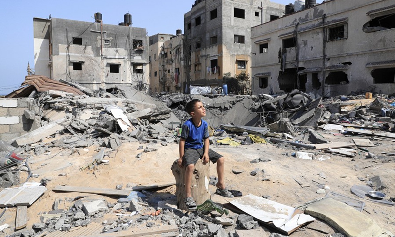 Palestinian Mohammad Shamlakh, 6, sits on the rubbles of his house which was damaged by an Israeli airstrike in Gaza City, on Aug. 9, 2022.(Photo: Xinhua)