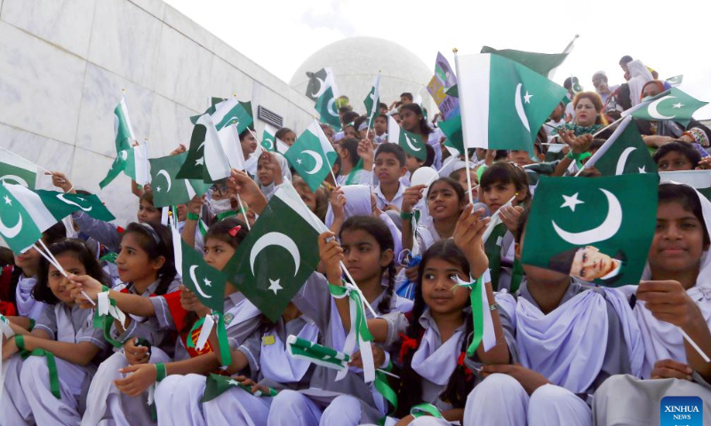 Pakistani students wave national flags during a ceremony to mark the country's Independence Day in southern Pakistani port city of Karachi on Aug. 14, 2022. Photo: Xinhua