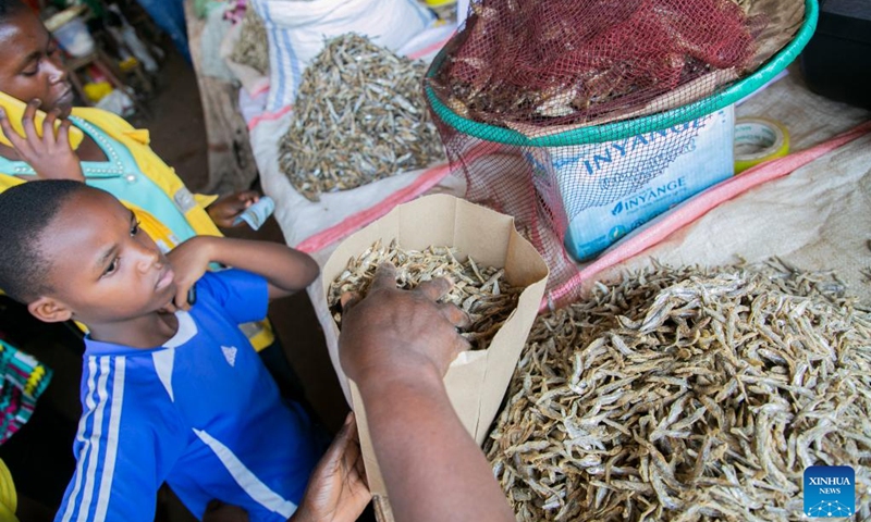 A vendor packs dried fish with a paper bag at Kimironko market in Kigali, Rwanda, July 14, 2022.(Photo: Xinhua)