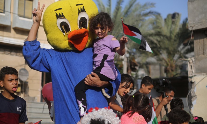 A Palestinian volunteer dresses as a duck to perform for refugee children to cheer them up after the Israel-Jihad conflict in the southern Gaza Strip city of Rafah, on Aug. 9, 2022.(Photo: Xinhua)