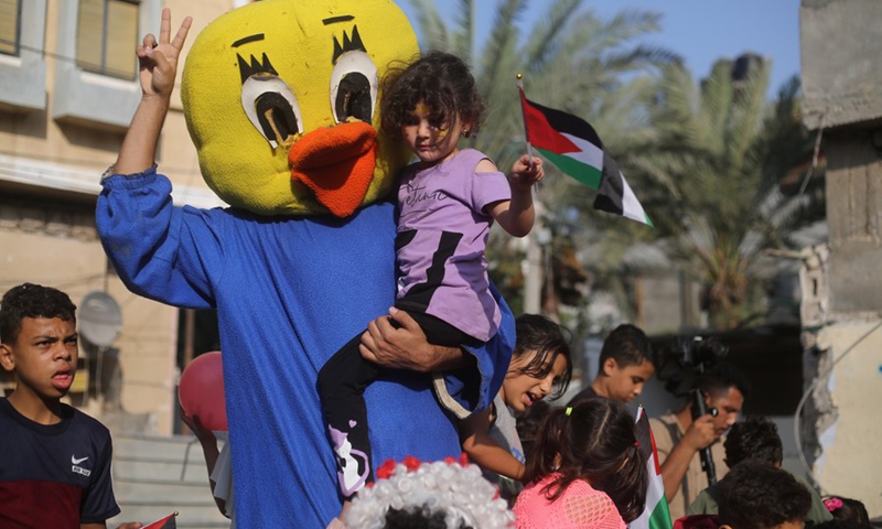 A Palestinian volunteer dresses as a duck to perform for refugee children to cheer them up after the Israel-Jihad conflict in the southern Gaza Strip city of Rafah, on Aug. 9, 2022.(Photo: Xinhua)