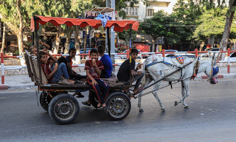 Gazan boys sit on a cart driven by a donkey walking in a public street in Gaza on the first day after the end of the Gaza-Israel conflict, Aug. 8, 2022. (Photo: Xinhua)