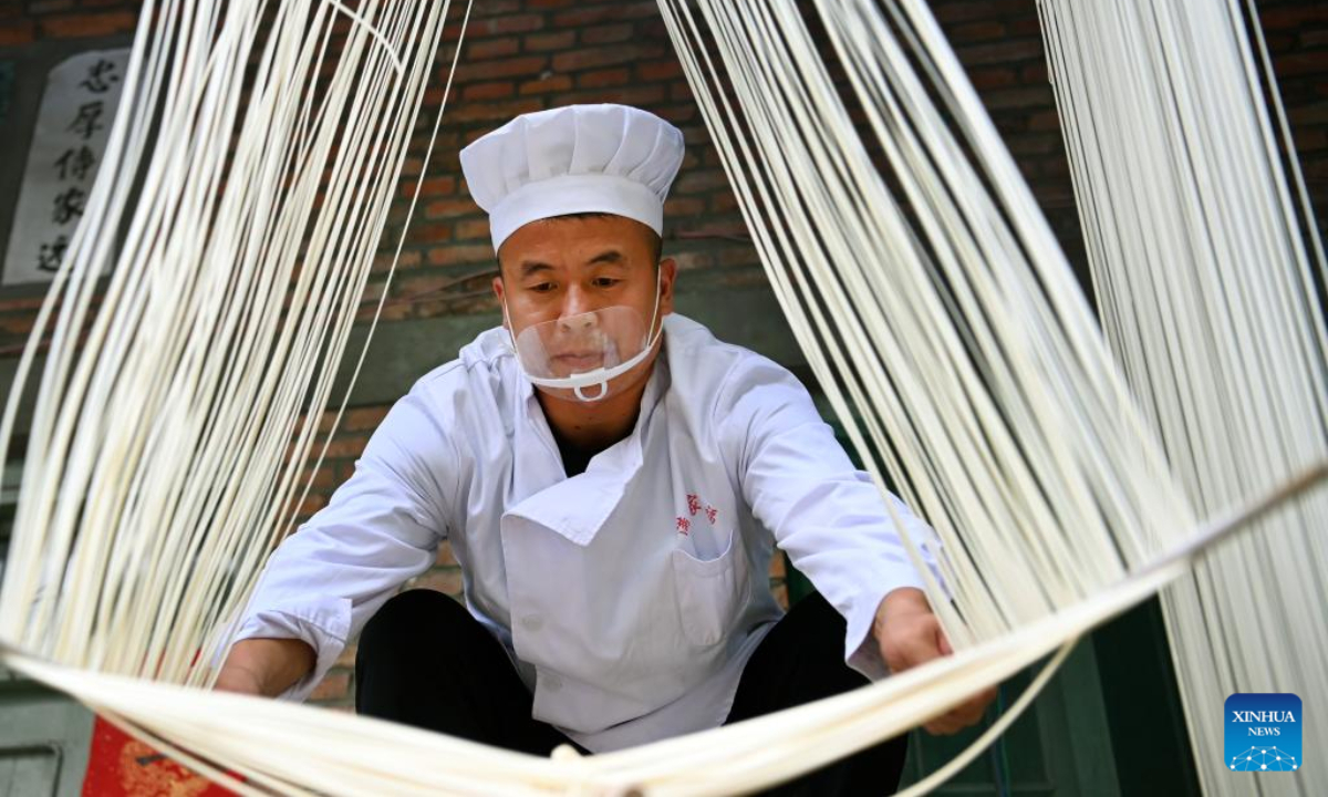 Li Nianping, son of Li Changman, dries hollow noodles in Meidi Village of Bao'an Township in Luonan County of Shangluo City, northwest China's Shaanxi Province, Aug 16, 2022. Li Changman, a 66 years old villager of Meidi Village, has learned the unique hollow noodle making skills since he was a teenager. He is the inheritor of Luonan handmade hallow noodle making skills which is listed as a provincial intangible cultural heritage. He encouraged his child to learn this skill, and also taught the skills to villagers to increase their income. Photo:Xinhua