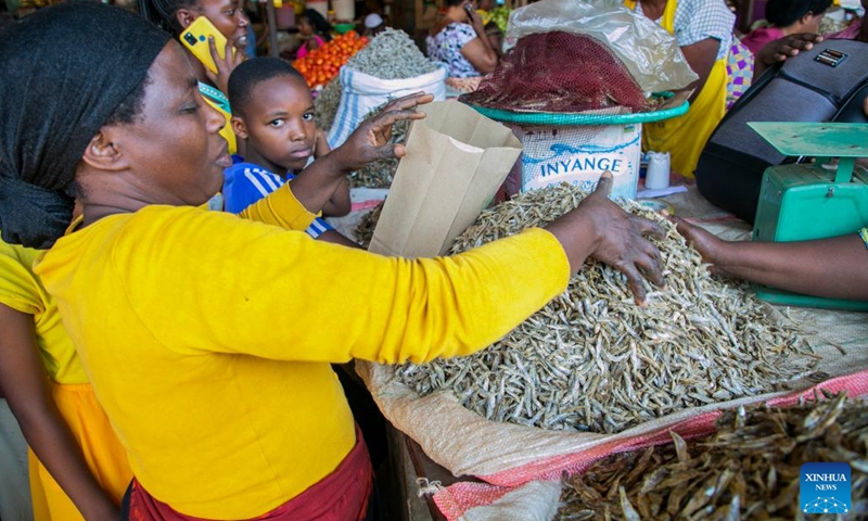 A vendor packs dried fish with a paper bag at Kimironko market in Kigali, Rwanda, July 14, 2022.(Photo: Xinhua)