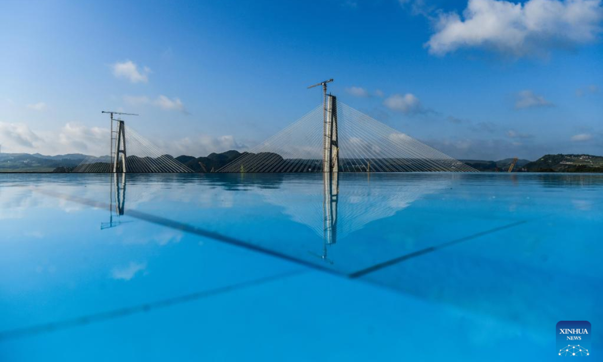 The construction site of the Longli River bridge is reflected in a pool of a hotel in Longli County, southwest China's Guizhou Province, Aug 19, 2022. The 1,260-meter-long bridge was joined together on Friday. Photo:Xinhua