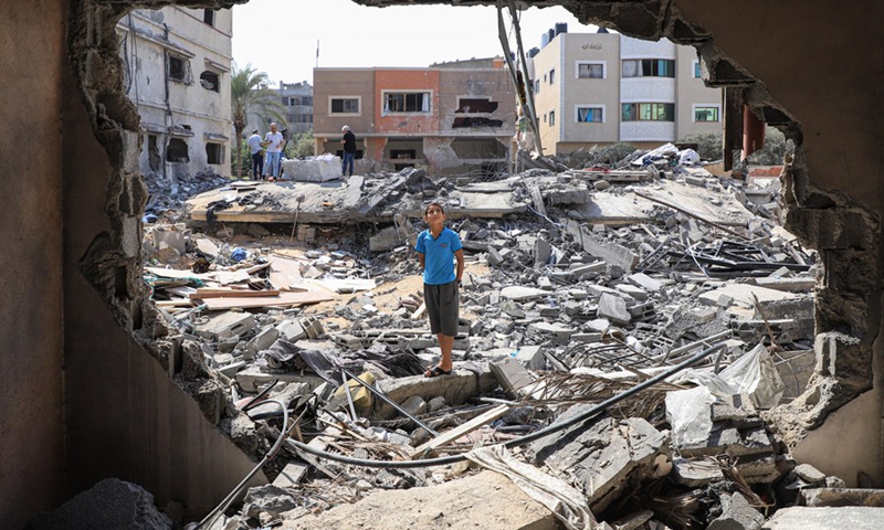 Palestinian Mohammad Shamlakh, 11, stands on the rubbles of his house which was damaged by an Israeli airstrike in Gaza City, on Aug. 9, 2022.(Photo: Xinhua)