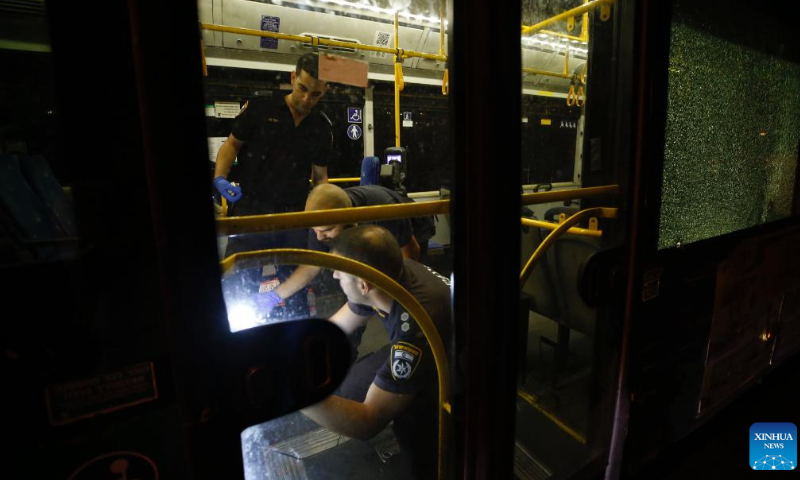 Israeli security force members investigate the scene of a bus shooting in Jerusalem, Aug. 14, 2022. A gunman shot at a bus in Jerusalem's Old City early Sunday, injuring at least seven people, according to local police and medics. Photo: Xinhua