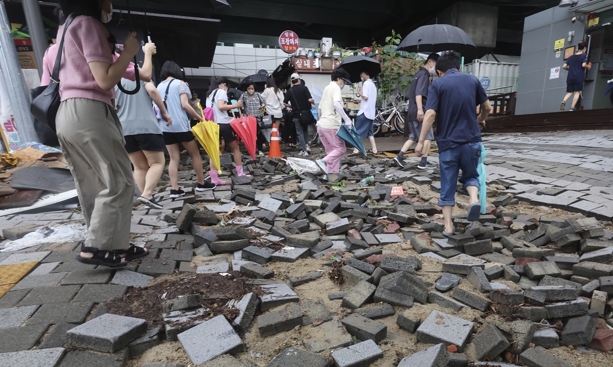 People walk on a damaged road near a subway station in Seoul, South Korea, on August 9, 2022. Photo: VCG