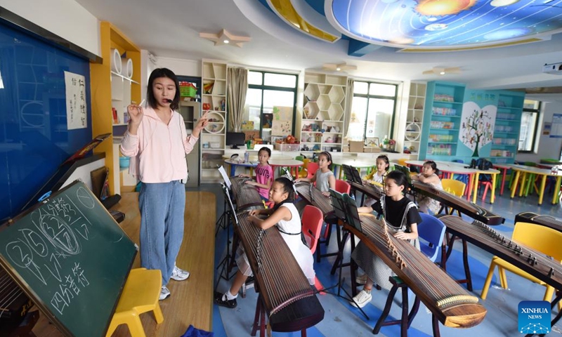 Students learn to play guzheng, or Chinese zither, in Hefei, east China's Anhui Province, Aug. 10, 2022. Some schools in Hefei now provide free daycare services for students this summer. The daycare programs not only help enrich students' summertime, but also ease the pressure on working parents who otherwise have to take care of their children during the holiday.(Photo: Xinhua)