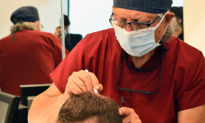 A Turkish doctor conducts hair implantation for a patient in Bursa, Türkiye, on Aug. 11, 2022.  Photo: Xinhua